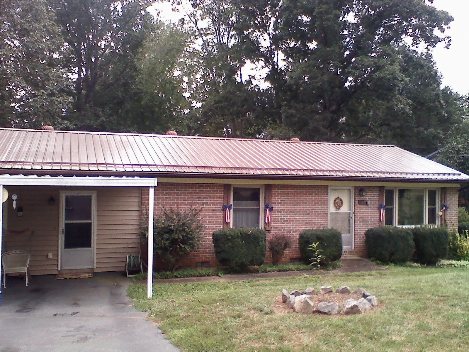Bronze metal roof and carport on a brick ranch home — Roof Repair work by our crew in Lindale